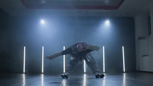 Young Woman Dancing on Stage with Smoke and Spotlight