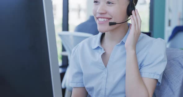 Young woman with headset working on computer