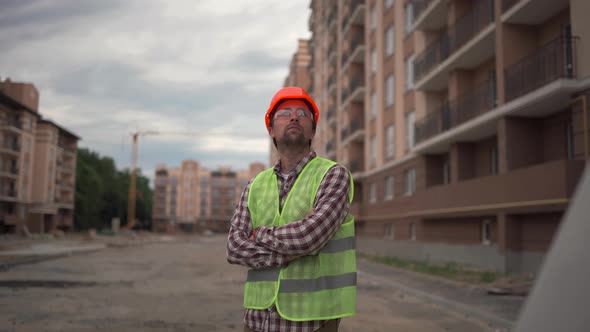 A Handyman in a Reflective Vest Helmet and Safety Glasses with His Hands on His Chest Proudly