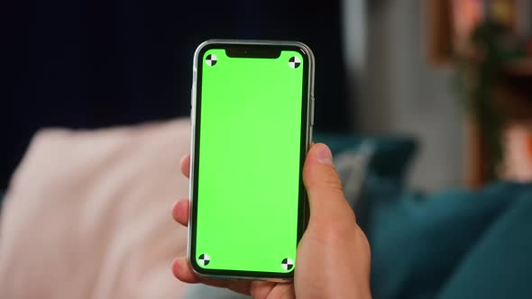 Closeup of a Man Hand Holding Green Mockup Chroma Key Screen Smartphone