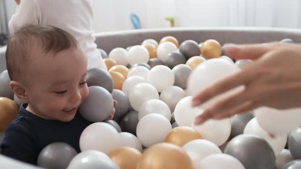 Delighted Toddler Laughing in Ball Pit