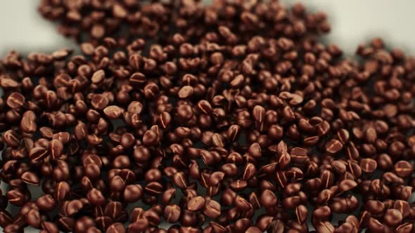 Brown grains that are creating a silhouette of the coffee cup with foam.