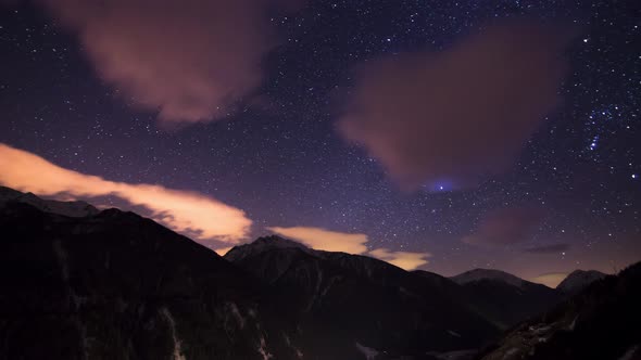 4K Time-lapse Cloudy starry dark night with the Milky Way, Orion and Jupiter