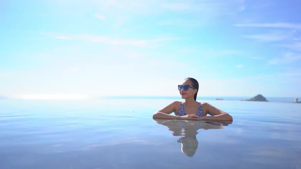 Young asian woman enjoy around outdoor swimming pool for leisure