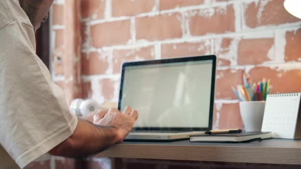 Asian man designer working home using laptop in living room at home.