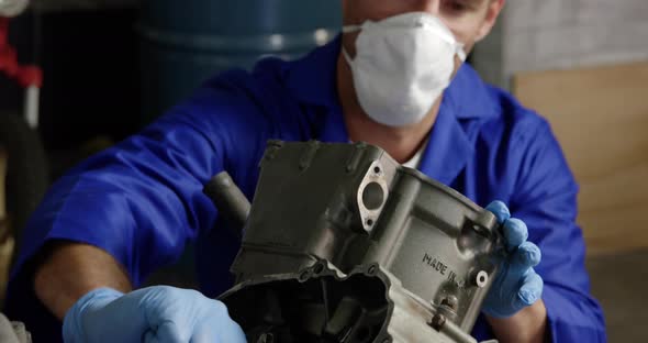 Male mechanic repairing motorbike engine in repair garage 4k