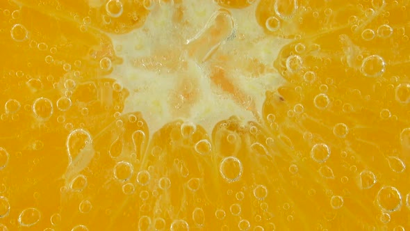 Air bubbles around an orange slice.