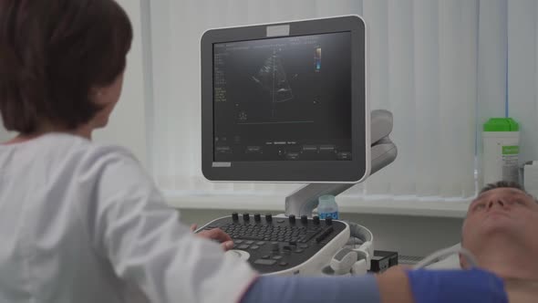 Doctor Using Ultrasound Machine to Scan Heart of a Male Patient
