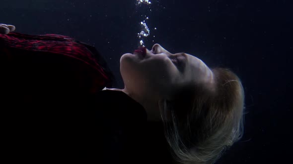 Busty Blonde with Red Lips Is Sinking in Depth, Open Eyes and Lifting Bubbles Air, Closeup