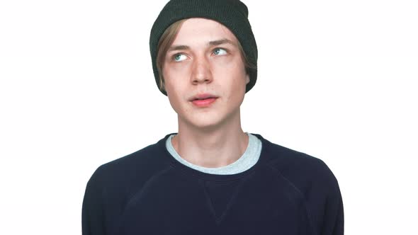 Portrait of Blueeyed Male Teenager in Sweatshirt and Hat Rolling Eyes Tired of Something Saying No