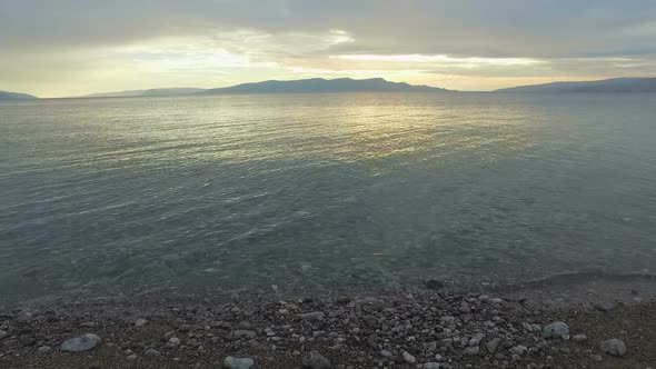 Tracking shot of sea and beach at sunset