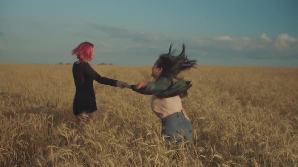 Lovely Women Rejoicing in Wheat Field at Sunset