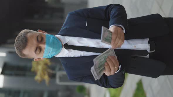 Cheerful Rich Handsome Businessman in Protective Face Mask Counting Money