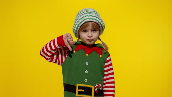 Displesed Kid Girl Christmas Elf Santa Helper Costume Keeps Thumb Down Shows Dislike Gesture