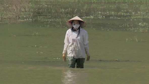 Vietnamese Woman Finishing Work of Cleaning Water From Weed