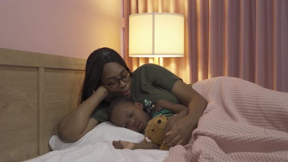 Portrait of smiling business black African american woman, a mom with her daughter lull the child