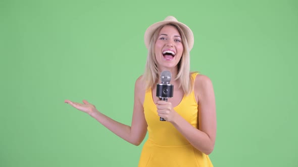 Happy Young Blonde Tourist Woman As Host Using Microphone