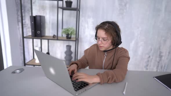 The Face of a Girl in Headphones Looking Towards the Laptop Screen While Studying Remotely