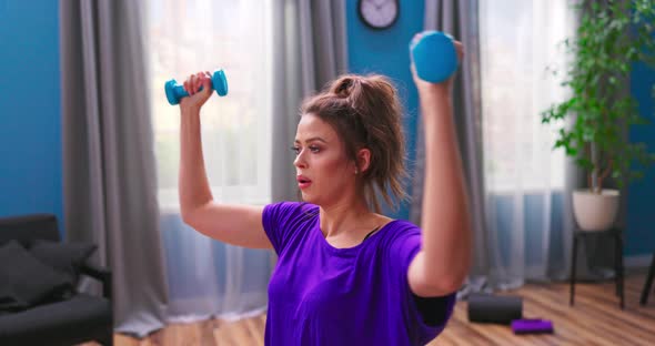 Determined Woman Losing Weight at Home and Exercising with Dumbbells