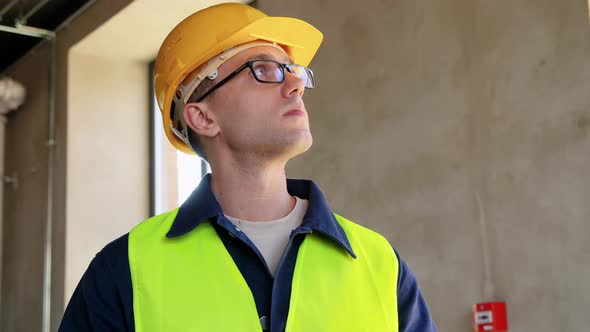 Builder in Helmet and Safety West with Tablet Pc