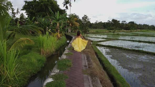 Woman Running Among Rice Fields in Bali