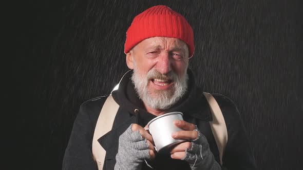 Portrait of Sad Old Senior Male Bum Wearing Warm Clothes Holding Can for Money