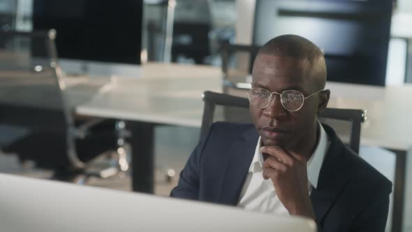 Serious African American Employee Thinking Over Business Email Working on Computer in Office Focused