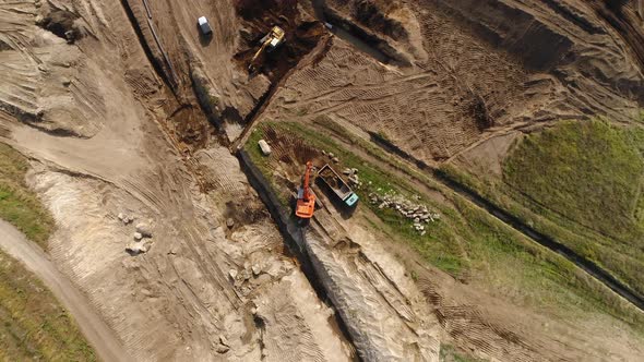 Excavator and Trucks Working on Farm