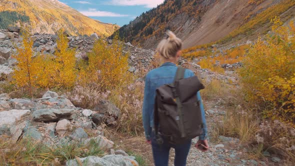 young tourist walks through mountainous area and looks at beautiful landscape.