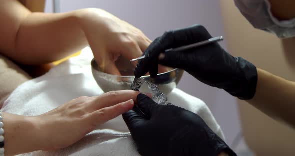 Cosmitologist Makes a Manicure to a Brunette in a Hairdressing Salon