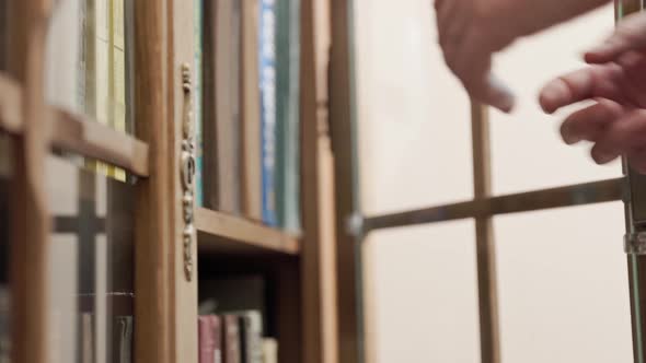 Caucasian woman handtake book on shelf. Concept of reading and education.