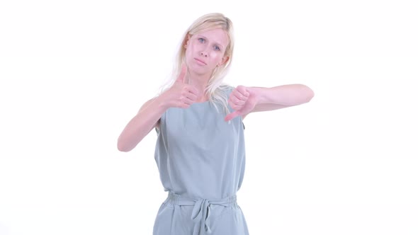 Confused Young Blonde Woman Choosing Between Thumbs Up and Thumbs Down