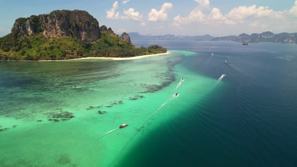 high altitude aerial of many thai longtail boats taking tourists on an island tour around the beauti