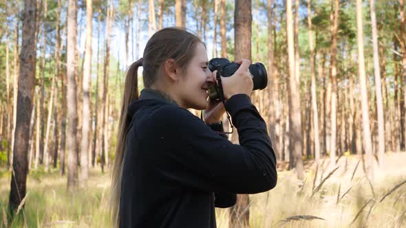 Video of Young Female Wildlife Photographer Making Images of Nature While Standing in High Grass 