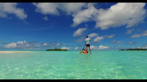 Guy and girl relax on tranquil shore beach break by transparent water and white sand background of t