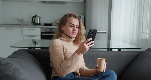 Happy Cheerful Positive Blonde Woman at Home Smiling Girl Using App and Browsing on the Internet