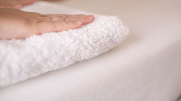 Woman Smoothing A Fresh White Towel