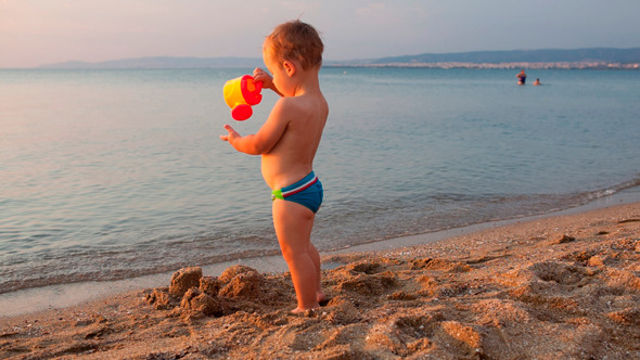 Little Boy On The Beach At Sunset