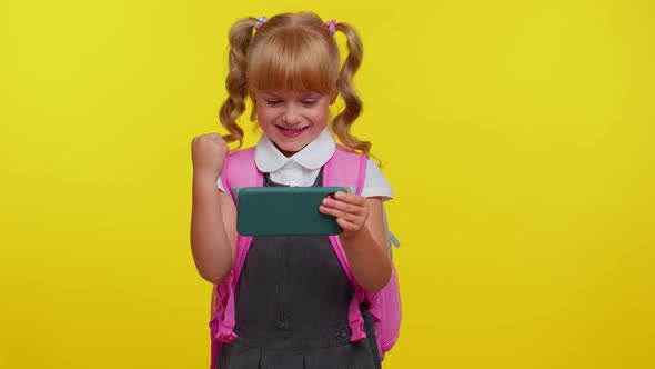 Worried Funny School Girl Wear Backpack Enthusiastically Playing Racing Video Games on Mobile Phone