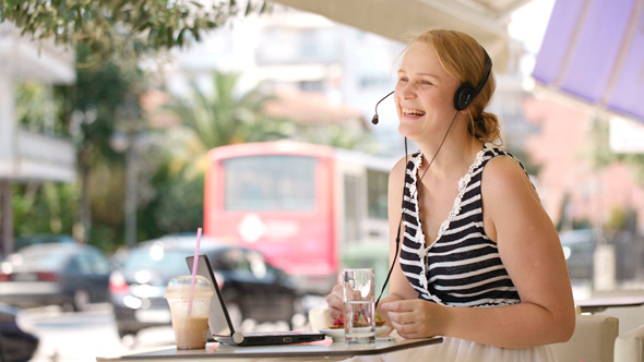 Laughing Woman Wearing A Headset In Outdoor Cafe