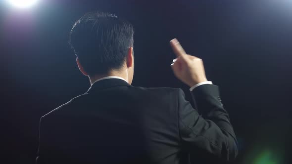 Close Up Back View Of Asian Speaker Man In Business Suit Showing Index Fingers Up While Speaking