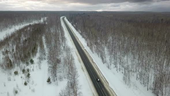 Cars On Winter Road And Cloudy Sky