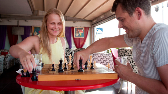 Smiling Couple Playing A Game Of Chess
