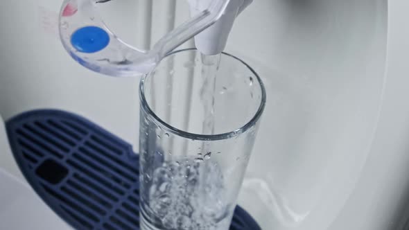 Water Cooler Clear Water is Pouring Into Glass From the Water Dispenser