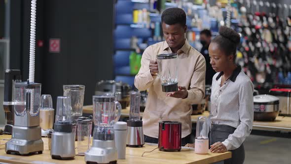 Shoppers in Home Appliances Store Black Man and Woman are Viewing Exhibition Samples of Blender