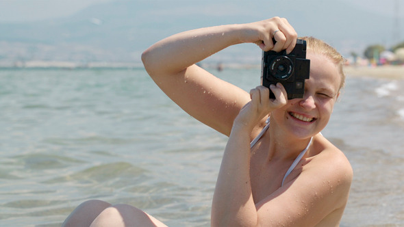 Smiling Woman Taking A Photo At The Seaside 