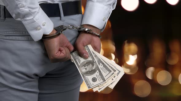 Side View Man in Handcuffs Holding Money.