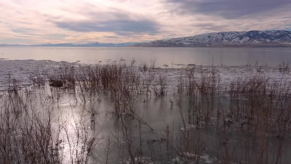 Utah Lake in winter flying over shoreline as lake is frozen