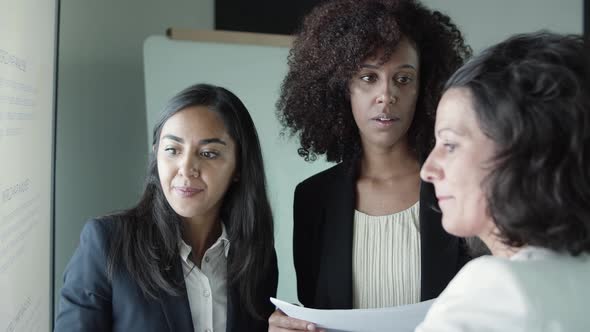 Serious Businesswomen Standing and Discussing Project