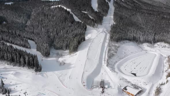 Aerial View of Skiers Go Down Ski Slopes Near Ski Lifts on Ski Resort. Bukovel